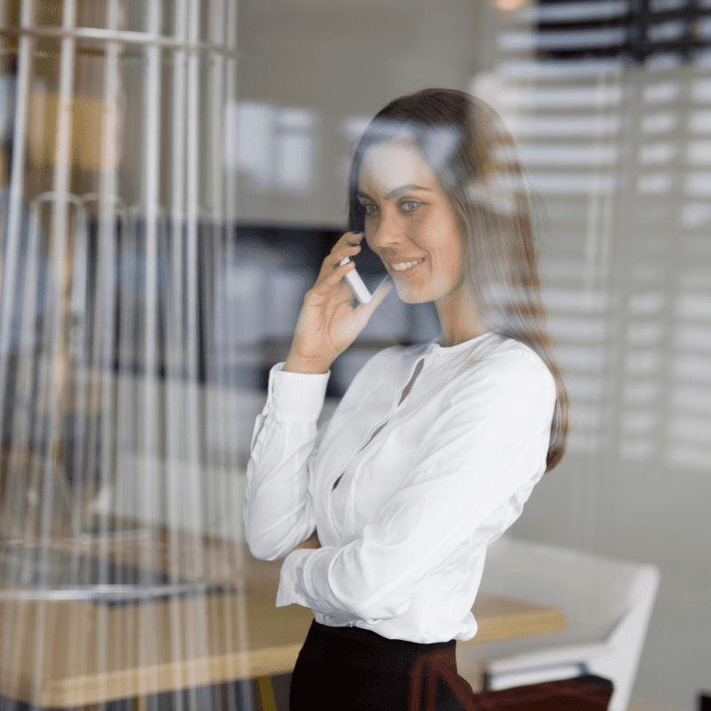 woman in office taking private phone call behind glass wall